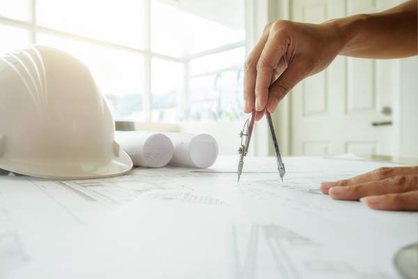 hands of an engineer working on blueprint for construction concept